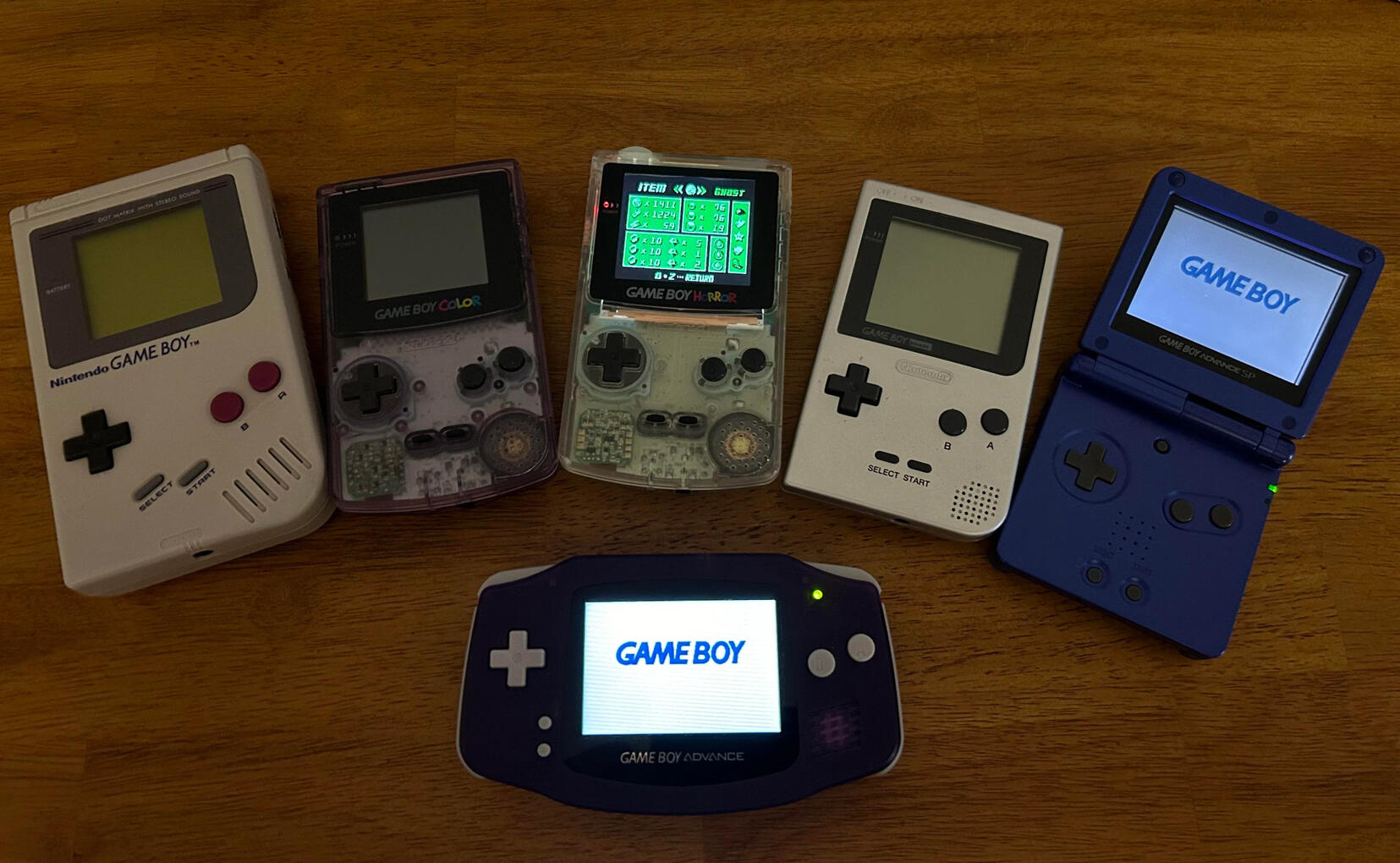 Listed left to right: Game Boy DMG (1989), Game Boy Color (1998), Game Boy Horror (2001), Game Boy Pocket (1996), Game Boy Advance (Bottom, 2001), Game Boy Advance SP (2003)